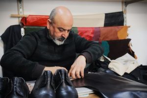 lux leather , ostrich leather good and man working on the workshop with ostrich materials