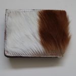 Springbok leather wallet with a distinctive natural pattern, featuring a rich blend of brown and cream colors, exuding rugged elegance and durability.